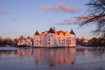 Fairytale water castle in dreamlike winter wonderland.