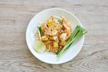 Pad Thai stir fried rice noodles with shrimp and egg on plate 