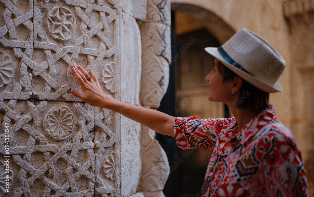 Wall mural female summer travel to Antalya, Turkey. young asian woman in red dress walk through old town Kalechi , female tourist traveler discover interesting places and popular tourist attraction