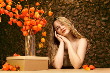 Girl with fesalis. A girl and a natural bouquet of orange dried flowers.  Natural rural look.