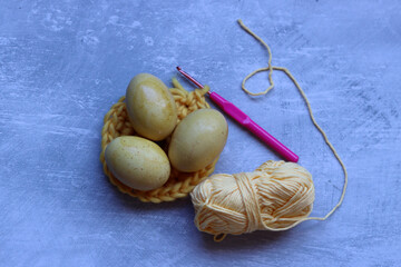 Easter eggs and cotton yarn threads on textured background with copy space. Easter decoration. 