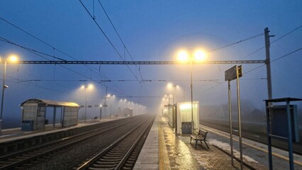 Night railway station. Abandoned railway station in fog. Concept of traveling, tourism or commuting...