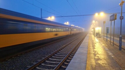 Passage of a passenger train to the station in fog. Night train passing through the station....