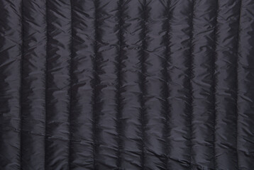 Black fabric of a men's winter jacket as a background, outerwear, jacket.