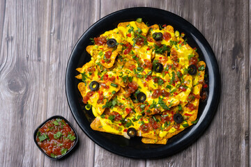 Nachos a Mexican culinary dish consisting of tortilla chips or covered with cheese or cheese sauce,...