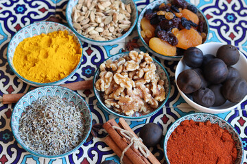 Spices and herbs in bowls on traditional Moroccan blue tiles background. 