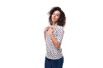 portrait of an authentic curly young brunette with shoulder-length hair dressed in a blouse on a...