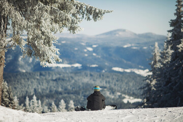 Snowboard sportsmen sitting on snow. One snowboarder ready for snowboarding on winter mountain top....