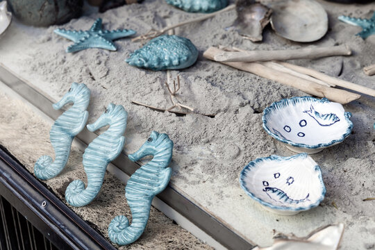 Shop window with ceramics on the sand. Ceramics on a marine theme, plates, shells and sea turtles.
