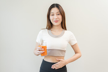 Orange detox juice, good digestive, smile asian young woman hand on stomach with glass of vegetable...