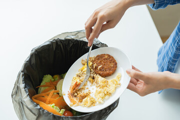Compost from leftover food, refuse asian young housekeeper woman, girl hand using fork scraping waste from dish, throwing away putting into garbage, trash or bin..Environmentally responsible, ecology.