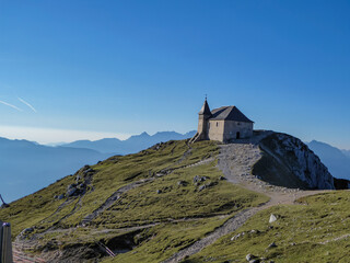 Scenic hiking trail at sunrise to chapel Maria am Stein on top of mountain peak Dobratsch,...