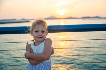 Little girl have a fun on embankment overlooking presidential palace and sunset in Abu Dhabi, UAE