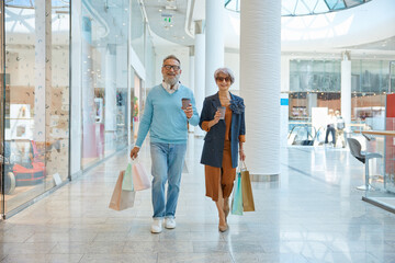 Fashionable elderly couple enjoying shopping tour on weekends