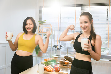 Attractive fitness asian woman finishing workout and drinking protein milk shake vitamins after...