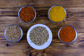 Bowls with oriental spices on a wooden table