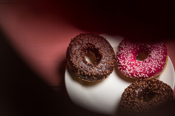 Chocolate and pink donut on a plate, delicious dessert