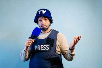 Reporter with bulletproof vest holding a microphone in studio.