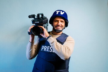 Reporter in bulletproof vest holding a video camera