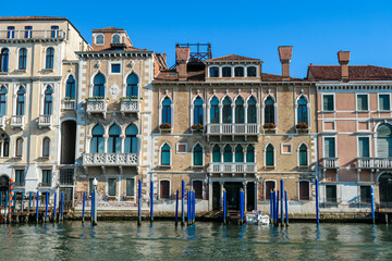Fototapeta na wymiar Scenic view of Grand Canal (Grand Canale) in Venice, Veneto, Italy, Europe. Luxury residential house area along the biggest water channel. Golden hour on the facades. Urban summer tourism