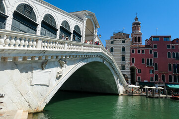 Channel Canal Grande with scenic view of famous Rialto bridge in city of Venice, Veneto, Northern Italy, Europe. Venetian architectural landmarks. Romantic vacation. Summer urban tourism