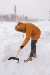 A man cleans and clears the snow in front of the house on frosty day. Cleaning the street from snow...