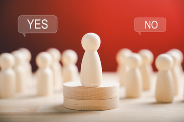 Wooden figures stand on a cube displaying yes or no symbols. Signifying open-mindedness in...