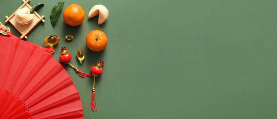 Composition with Chinese fan, tangerines and symbols on green background. Banner for design