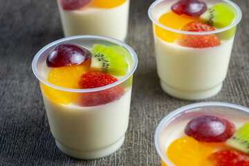puding sutra leci or lychee silk pudding with kiwi, grape, orange and strawberry pieces on top. has a soft texture and tastes fresh. healthy food