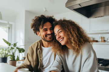 Portrait of couple having a coffee, tea in modern kitchen, mixed race. Spending mornings together. Intimate moment. - obrazy, fototapety, plakaty