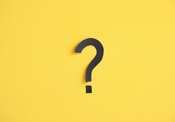 Paper question mark on yellow background