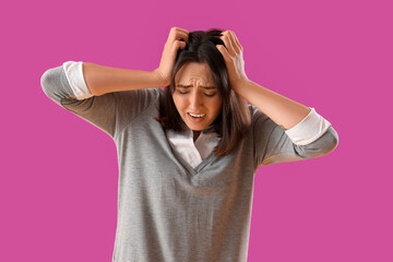 Beautiful young afraid woman on purple background