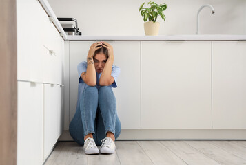 Scared young woman in kitchen
