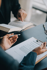 Justice and law concept.Male judge in a courtroom with the gavel, working with, computer and docking keyboard, eyeglasses, on table in morning light