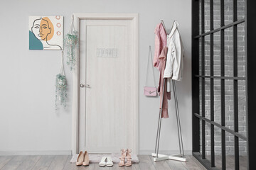 Interior of hall with door, mat and clothes rack