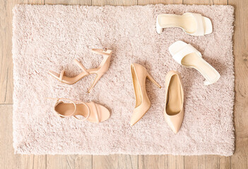 Doormat with stylish heels on floor, top view