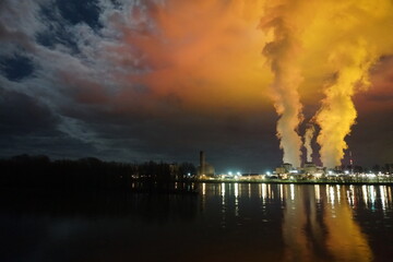 nuclear plant at night with a colorful moonrise by the loire river  in france with mirror...