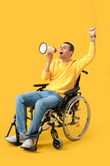Young man in wheelchair shouting into megaphone on yellow background