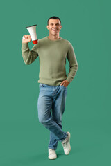 Young man with megaphone on green background