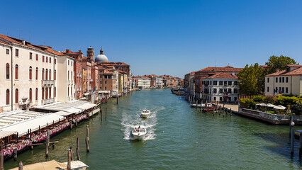 Panoramic view of water channel grand canale in city of Venice, Veneto, Northern Italy, Europe. Venetian architectural landmarks and old houses facades seen from gondola. Urban tourism in summer