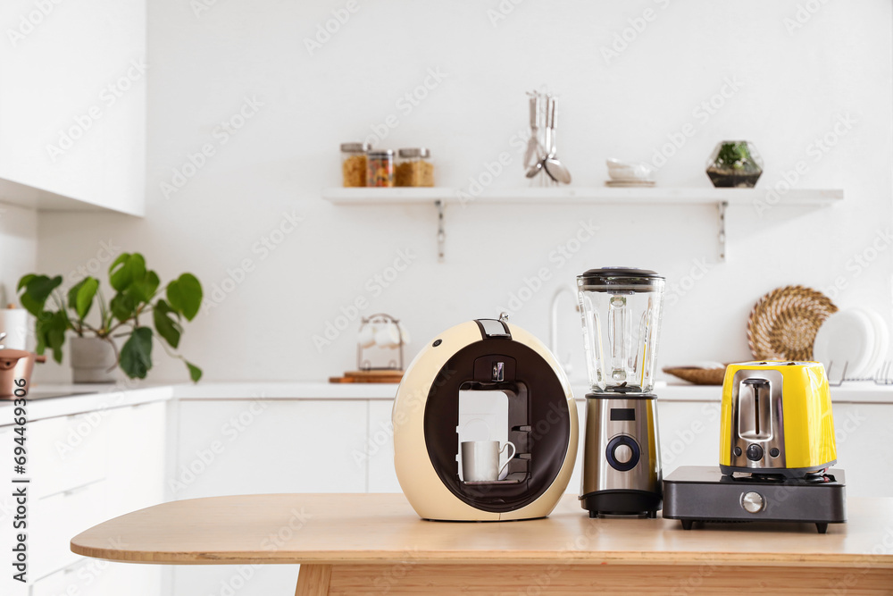 Canvas Prints Wooden table with set of modern appliances in light kitchen