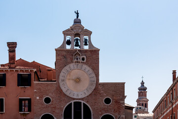 Fototapeta na wymiar Close up view of church Chiesa di San Giacomo di Rialto in Venice, Veneto, Northern Italy, Europe. Old landmark and Venetian architecture. Astronomical clock on top of building. Sightseeing in city