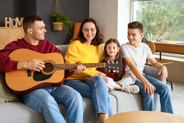 Young man playing guitar and his family at home