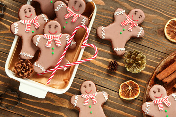 Baking dish with Christmas sweet gingerbread cookies and candy canes on wooden background