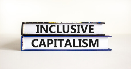 Inclusive capitalism symbol. Concept words Inclusive capitalism on beautiful books. Beautiful white table white background. Business inclusive capitalism concept. Copy space.
