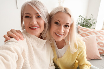 Mature female friends taking selfie at home, closeup