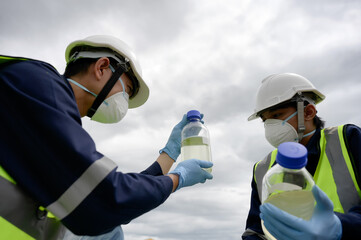 Environmental Engineers Team Take Water Samples at Natural Water Sources in a bottle. Water that...