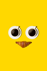 Poster with smiling face with two cups of coffee and croissant  on yellow background, minimalism art, flat lay, copy space