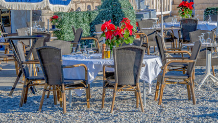 Fototapeta na wymiar Tables de restaurant de plage au bord de la baie des anges à Nice sur la Côte d'Azur