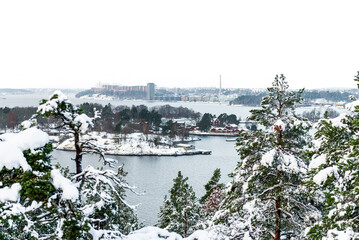 winter landscape. view of lake malaren, island Fjaderholmarna and Stockholm in Sweden, snow-covered trees and pines. - obrazy, fototapety, plakaty